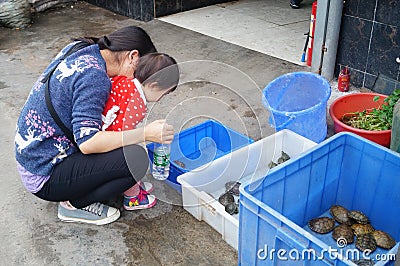 Shenzhen, China: a young mother with her daughter in the aquarium Editorial Stock Photo