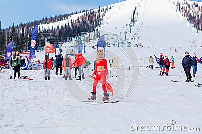 Sheregesh, Kemerovo region, Russia - April 12, 2019: Young happy pretty woman dressed in carnival costume of a red devil riding on Editorial Stock Photo