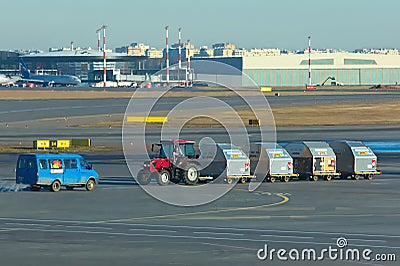 Sheremetyevo, Moscow, Russia. 12/04/2019. Ground service personnel. Unfocused tractor and luggage carts traveling at the airport. Editorial Stock Photo