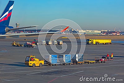 Sheremetyevo, Moscow, Russia. 12/04/2019. Ground service. Unfocused luggage carts, tanker and others, traveling ontu the airport. Editorial Stock Photo