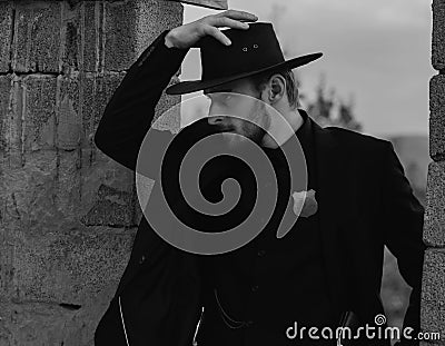 Sheriff or cowboy in black suit and cowboy hat. Man with west vintage pistol revolver gun. American western, sheriff. Stock Photo