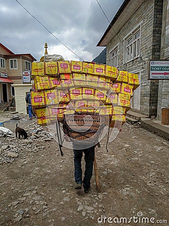 Sherpa porter carrying a heavy load in Nepal Editorial Stock Photo