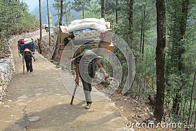 Sherpa porter carry basket in Nepal trekking path Editorial Stock Photo