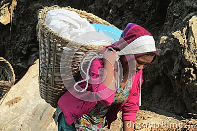 Sherpa porter woman carry heavy loaded basket in Nepal Editorial Stock Photo