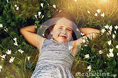 Shes a little nature lover. a cute little girl lying in a field of wildflowers outside. Stock Photo