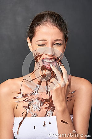 Shes a lover of chocolate. Studio shot of an attractive young woman being tempted by something sweet. Stock Photo