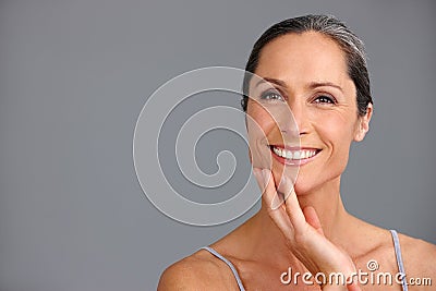 Shes still radiantly beautiful. Studio portrait of a beautiful mature woman posing against a gray background. Stock Photo