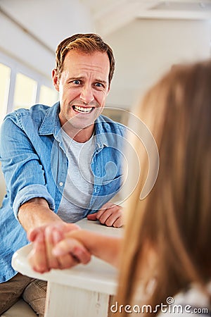 Shes stronger than she looks. a smiling father and his little daughter arm wrestling together at home. Stock Photo