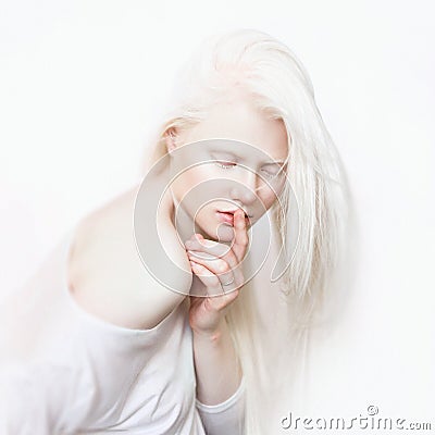 Shhh gesture. Albino female with white skin and white long hair. Photo face on a light background. Blonde girl Stock Photo