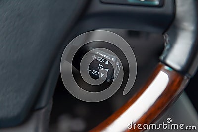 The shift lever to set the automatic cruise control speed inside the car close-up located near the steering wheel in black with Stock Photo