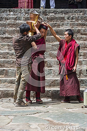 Tibetan Buddhist monks prepare butter tea in courtyard of Tashilhunpo Monastery . Shigatse , Tibet Editorial Stock Photo