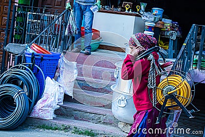 Indian Women walking on street.lifting heavy electric cable roll on her head Editorial Stock Photo