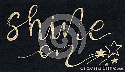 `Shine on` hand lettering motivational quote in golden writting on a black paper Stock Photo