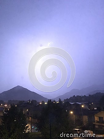 Shine and thunderstorm above mountain and city Stock Photo