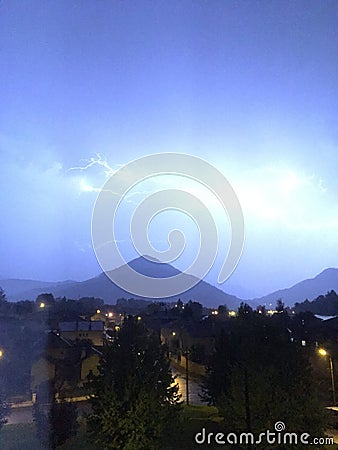 Shine and thunderstorm above mountain and city Stock Photo
