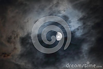 Shining moon with rushing clouds in the stormy, horrorous night sky long exposure color photo. Stock Photo