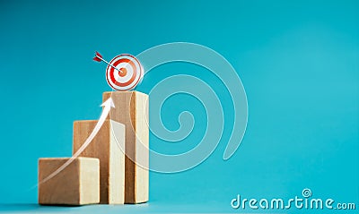 Shining rise up arrow shoot up towards the goal, 3d target icon on the top of wooden cube blocks. Stock Photo