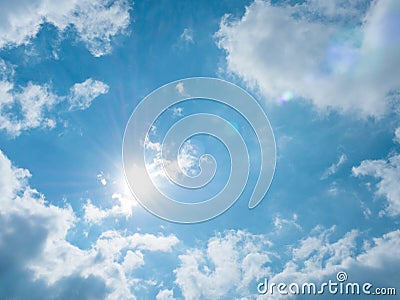 Shining sun and clouds on blue sky background Stock Photo