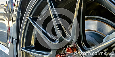 Shiny black car with black rim and red lug nuts Stock Photo