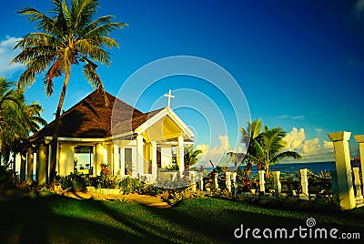 Shiny and bright church on the beach with coconut palm trees on pacific island Stock Photo