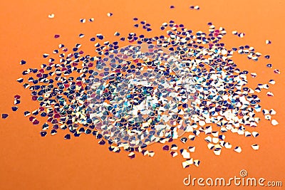 Shiny bright glitter scattered on coral background Stock Photo