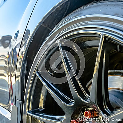 Shiny car with black mag wheel and red lug nuts Stock Photo