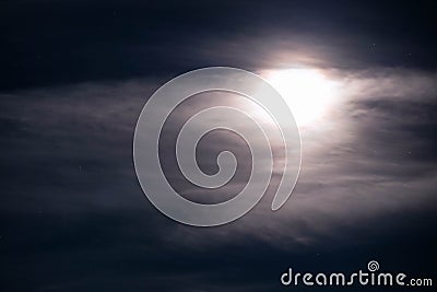 Shiny full Moon behind cloud on night starry sky Stock Photo