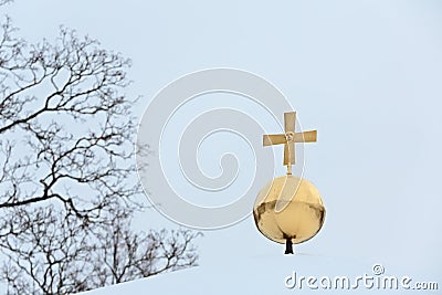 Shiny, gilded and religious symbol with small skull Stock Photo
