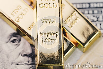Shiny gold bullions ingot stack on america US dollar banknote mo Stock Photo