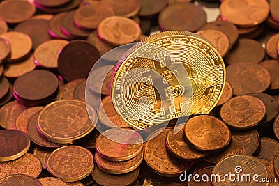 Shiny golden Bitcoin sticking out from pile of old coins Stock Photo