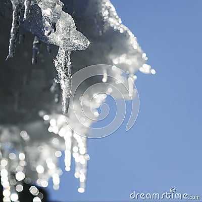 Shiny icicles melt and drip on the roof in the spring Stock Photo