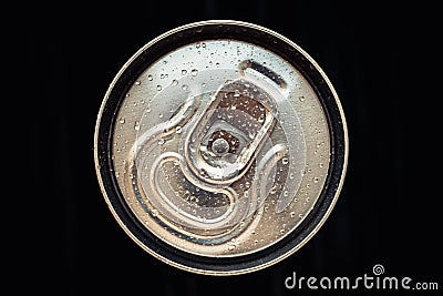 Shiny metal cola can lid with water drops on black background. Golden bottle of drink, lid of packaging of beer. Top view Stock Photo