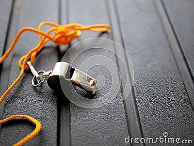 Shiny metal whistle with bright orange lanyard. Stock Photo