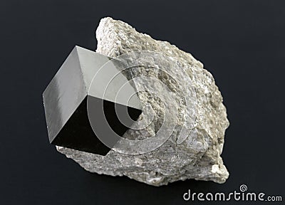 Shiny smooth regular shape pyrite cube on a dark background Stock Photo