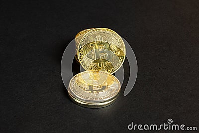Shiny stack bitcoin coins on black paper textured background, close up view Stock Photo