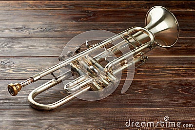Shiny trumpet on brown wooden background. Stock Photo