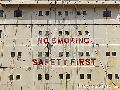 A ship crew chipping the accomodation front of ship for painting Stock Photo