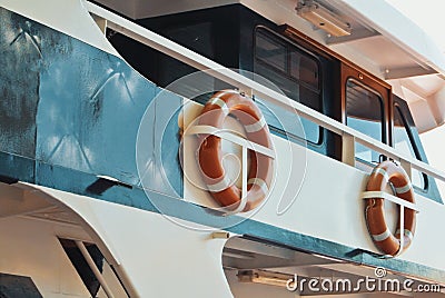 Ship details, two orange lifebuoys life savers rings hanging attached at the upper deck of a cruise ship. Stock Photo