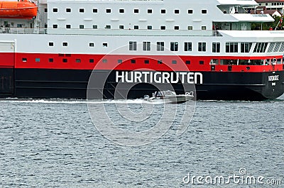 The ship hurtigruten entering tromsoe harbour with speeding small boat passing it Editorial Stock Photo