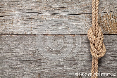 Ship rope knot on wooden texture background Stock Photo