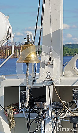 The ship`s bell on the bow with elements of the rigging of the ship on a Sunny day vertically Stock Photo