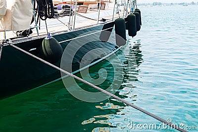 Ship's bow and aquamarine water in the port of Syracuse, Sicily. Boat and sea, detail. Sailing vessel drops anchor Stock Photo