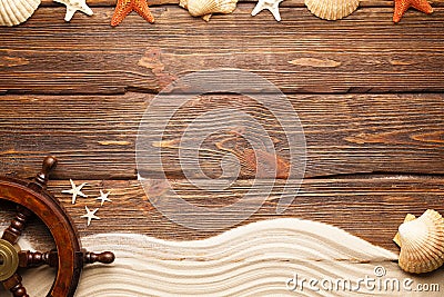 Ship`s steering wheel, beach sand and shells on wooden wall back Stock Photo