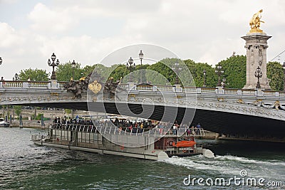 Ship with tourists floats under the bridge of Alexander lll Editorial Stock Photo