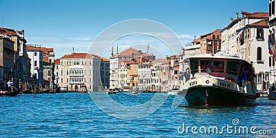Ship transporting tourists on the Grand Canal, with panoramic view of old picturesque buildings and boats behind Editorial Stock Photo