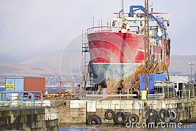 Ship wreck vessel and rescue lift crane at port dock for repair of capsized boat Stock Photo