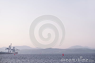 Shipbuilding port and ships at dock with crane at sunset coastal view Stock Photo
