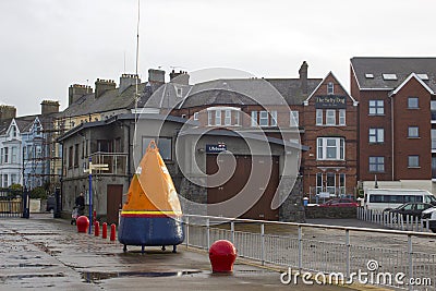 A shipping marker buoy that has been converted to a huge money box for donations to the RNLI outside their boathouse and offices Editorial Stock Photo