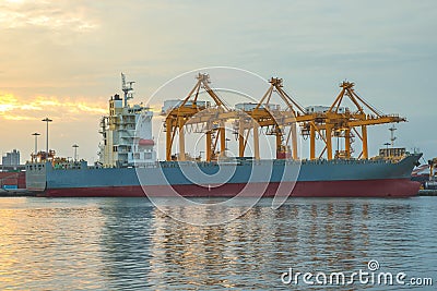 Shipping port with crane for container uploading at dusk Stock Photo