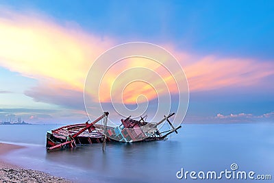 Shipwreck or wrecked boat on beach in the sunset. Beautiful Landscape. Stock Photo